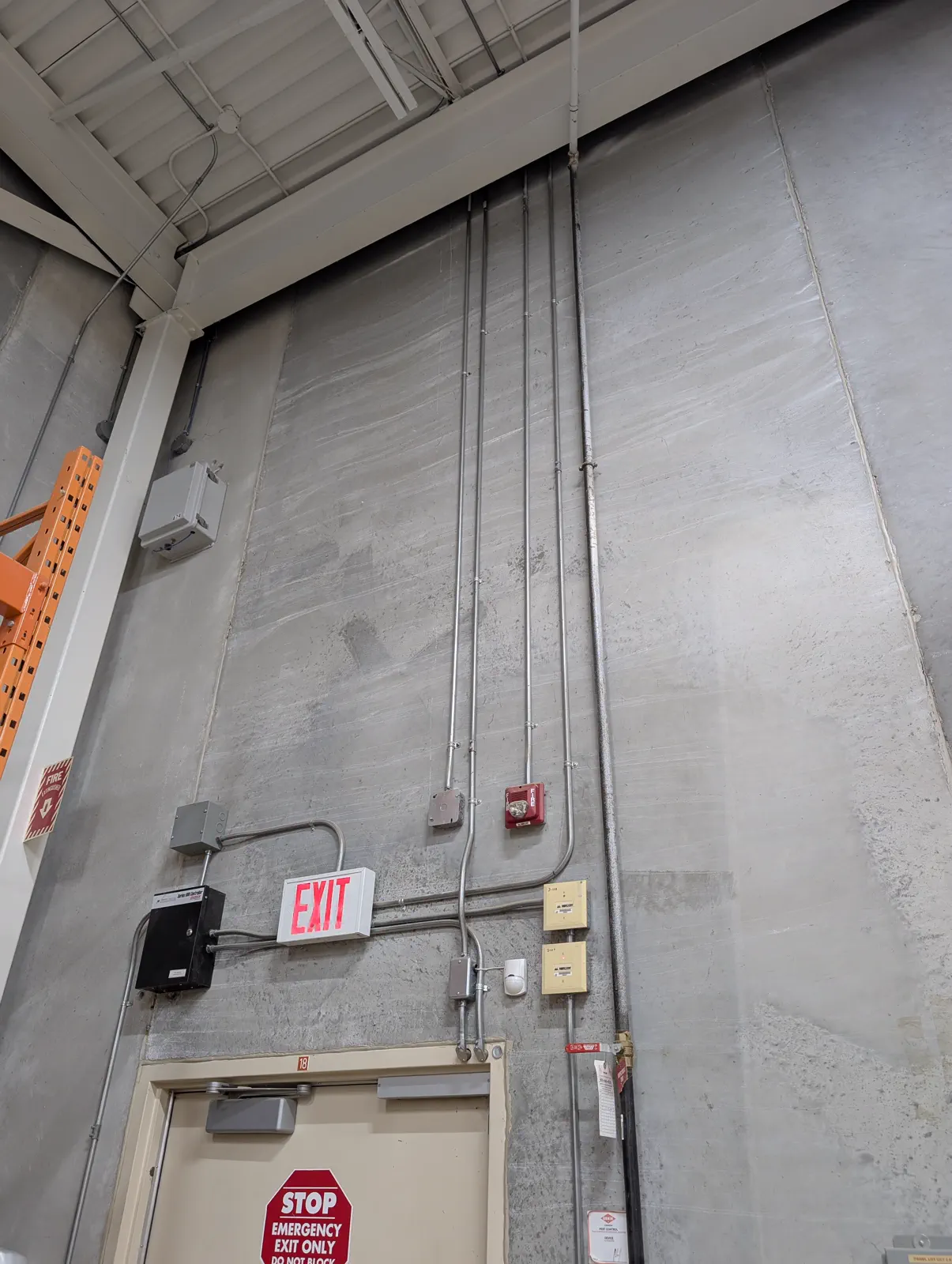 Commercial wall conduit and electrical boxes in a work area.